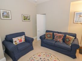 A living room with two sofas and wall art at Raglan Lodge in Monmouth