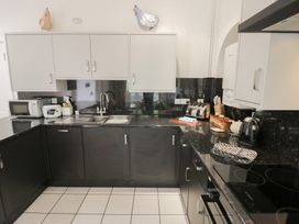 A kitchen with cabinets, sink, microwave, toaster and kettle at Raglan Lodge in Monmouth
