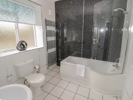 A bathroom with a bath tub and toilet at Raglan Lodge in Monmouth