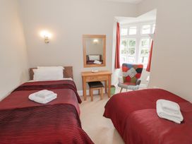 A bedroom with two beds and a mirror at Raglan Lodge in Monmouth