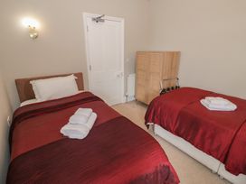 A bedroom with two beds and a wardrobe at Raglan Lodge Monmouth