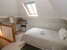 A bedroom with a bed and window at Raglan Lodge in Monmouth