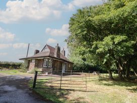 A house and trees with a gate in front at Raglan Lodge Monmouth