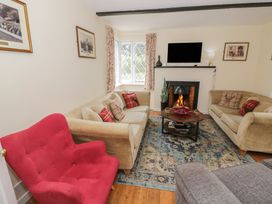 A living room with sofas and a fireplace at Hillside Cottage