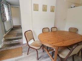 A dining room with a wooden table and chairs at Hillside Cottage