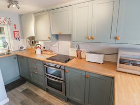 A kitchen with a sink and stove at Hillside Cottage 