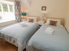 A bedroom with twin beds and a window at Hillside Cottage