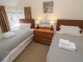 A bedroom with twin beds and a wooden chest of drawers at Hillside Cottage