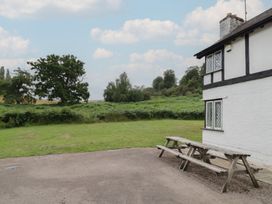 A table and benches outside a building at Hillside Cottage
