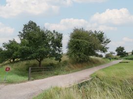 A path leading to a gate with trees at Hillside Cottage