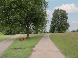 A pathway with a sign pointing to Raglan Lodge in an outdoor area