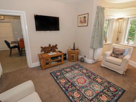 A living room with a television and chair at Boxbush Lodge in Monmouth