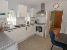 A kitchen with appliances and a table at Boxbush Lodge in Monmouth