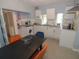 A kitchen with appliances and dining table at Boxbush Lodge in Monmouth