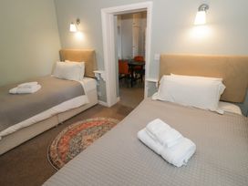 A bedroom with two beds and a doorway leading to a dining area at Boxbush Lodge in Monmouth