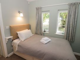 A bedroom with a bed and bedside lamp at Boxbush Lodge Monmouth