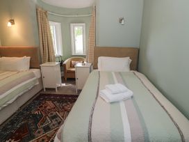 A bedroom with two beds and a chair at Boxbush Lodge in Monmouth