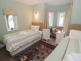 A bedroom with two beds and a chair at Boxbush Lodge in Monmouth