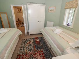 A bedroom with two beds and a wardrobe at Boxbush Lodge in Monmouth