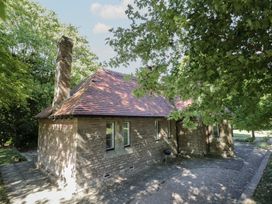 A house with a chimney and windows surrounded by trees at Boxbush Lodge Monmouth