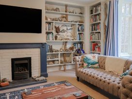 A living room with a television and bookshelf at 5B Bridge Street in Lyme Regis