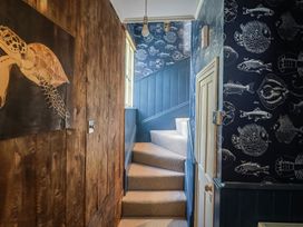 A stairway with a turtle painting and fish wallpaper at 5B Bridge Street in Lyme Regis