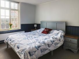 A bedroom with a bed, bedside table, flowers in a vase at 5B Bridge Street Lyme Regis