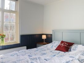 A bedroom with a bed, lamp and window at 5B Bridge Street in Lyme Regis