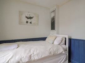 A bedroom with a bed and wall art at 5B Bridge Street in Lyme Regis
