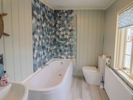 A bathroom with a bathtub, shower, toilet and sink at 5B Bridge Street Lyme Regis