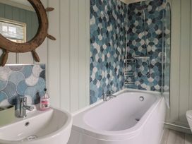 A bathroom with a bath, sink, and colorful tiles at 5B Bridge Street in Lyme Regis