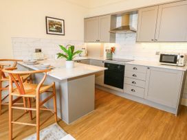 A kitchen with cabinets and countertop at 123 On The Sea - The Cubby in Weymouth