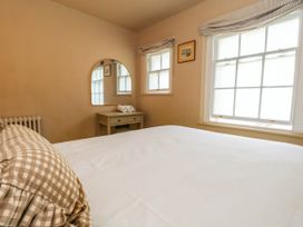 A bedroom with a bed and nightstand at 123 On The Sea - The Cubby in Weymouth