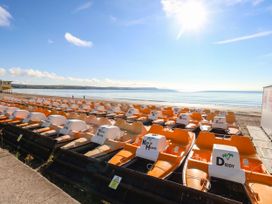 A row of pedal boats on a beach at 123 On The Sea - The Cubby, Weymouth