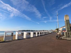 A row of beach huts by the sea at 123 On The Sea - The Cubby Weymouth