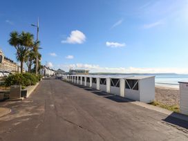 A row of beach huts along a road by the sea at 123 On The Sea - The Cubby in Weymouth