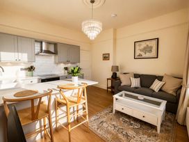 A living room with a kitchen island and stools at 123 On The Sea - The Cubby, Weymouth