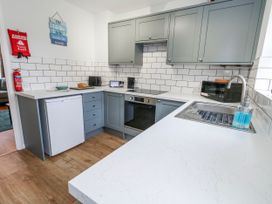 A kitchen with a sink, fridge, oven and microwave at 23 The Maltings in Weymouth
