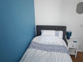A bedroom with a bed and nightstand at Dolphin Cottage in Weymouth