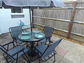A garden seating area with a table and chairs at Dolphin Cottage in Weymouth
