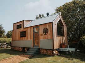 A wooden house with a door and windows at Driftwood in Carreglefn near Llanfechell