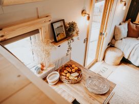 A kitchen with a table and fruit at Driftwood in Carreglefn near Llanfechell