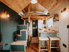 A kitchen with a bar and staircase at Driftwood in Carreglefn near Llanfechell