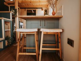 A kitchen with a countertop and two stools at Driftwood in Carreglefn near Llanfechell