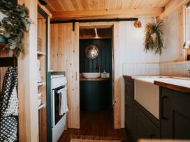 A kitchen featuring cabinets and a stove at Driftwood in Carreglefn near Llanfechell