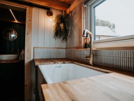 A kitchen with a sink and wooden countertop at Driftwood in Carreglefn near Llanfechell