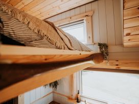 A bedroom with a loft bed and a window at Driftwood near Carreglefn