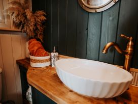 A bathroom with a sink and wooden countertop at Driftwood near Carreglefn