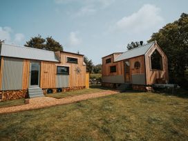 Two wooden houses with gardens at Driftwood near Carreglefn