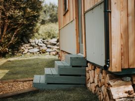 A set of steps leading to a wooden building at Driftwood Carreglefn near Llanfechell